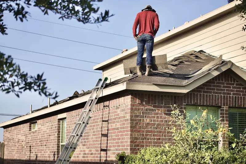 Professional roofer working on a residential roof in Phillips Park